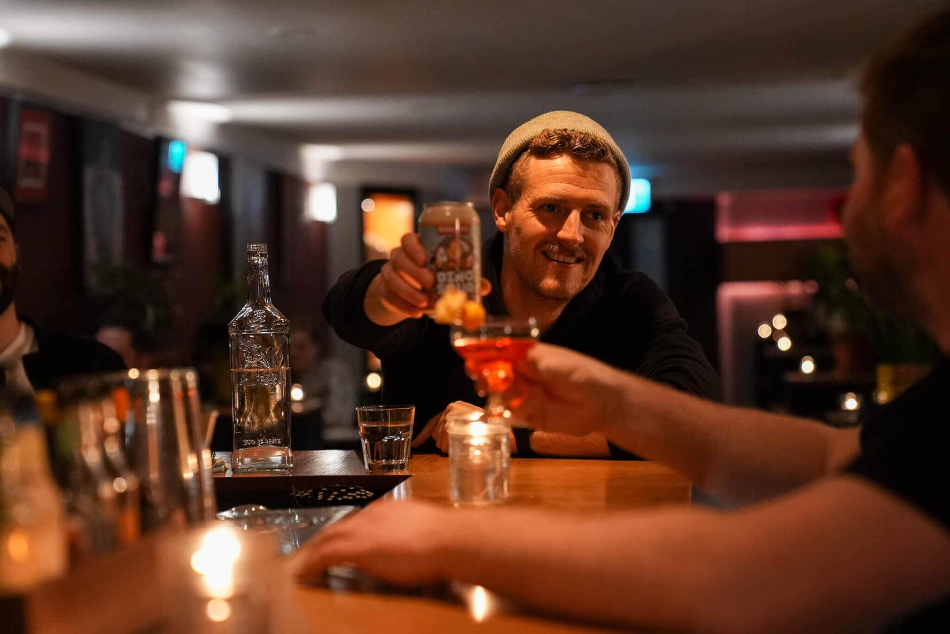 Guests toasting craft cocktails in the candlelit room at Cenote